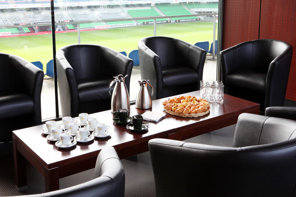 Pause café dans la salle Breizh Klub du Roazhon Park, donnant sur la pelouse du stade.