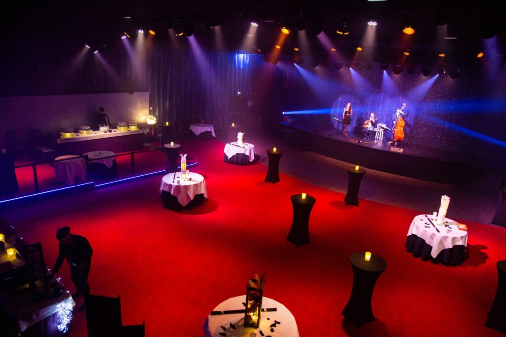 Salle du Cabaret Moustache aménagée en format cocktail avec 1 chanteuse et 2 musiciens sur scène